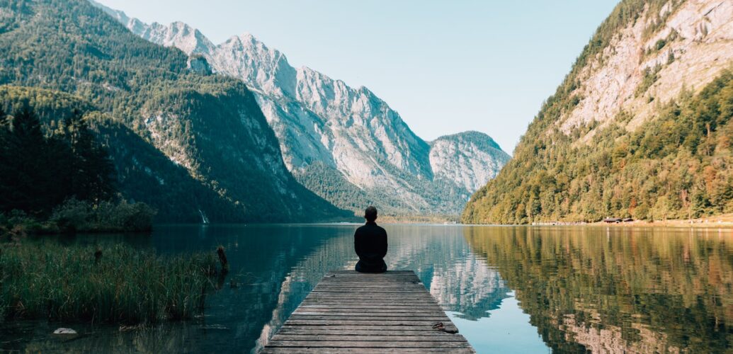 person on a bridge near a lake