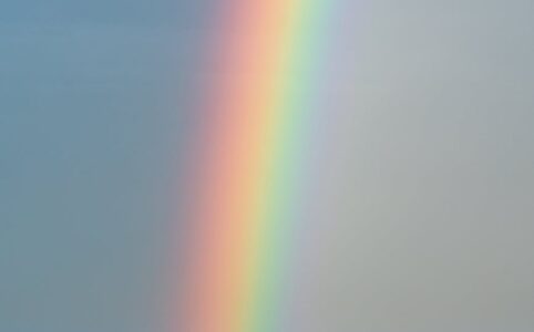 sky with rainbow over rippling blue ocean