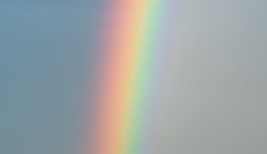 sky with rainbow over rippling blue ocean