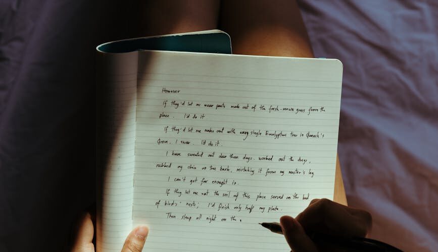 crop lady with pen and notebook on bed at home