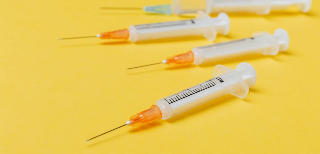 syringe injectors placed on yellow surface