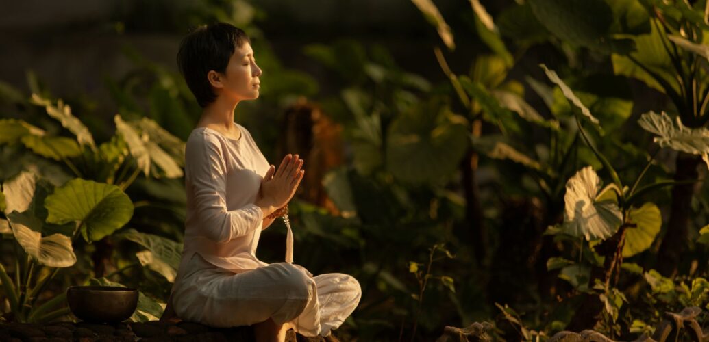 woman meditating in a garden at dawn