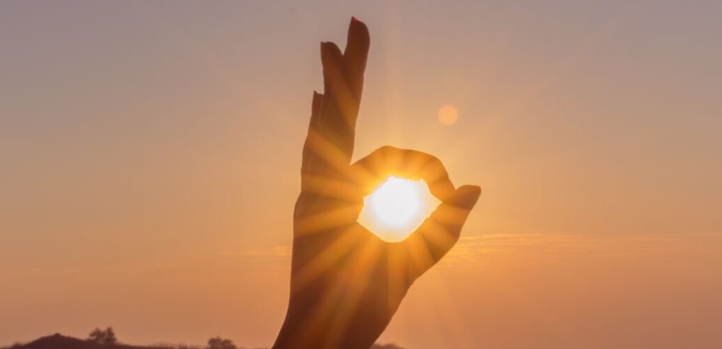 photography of hand during sunset