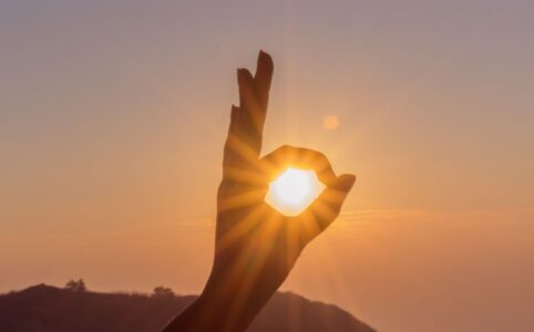 photography of hand during sunset